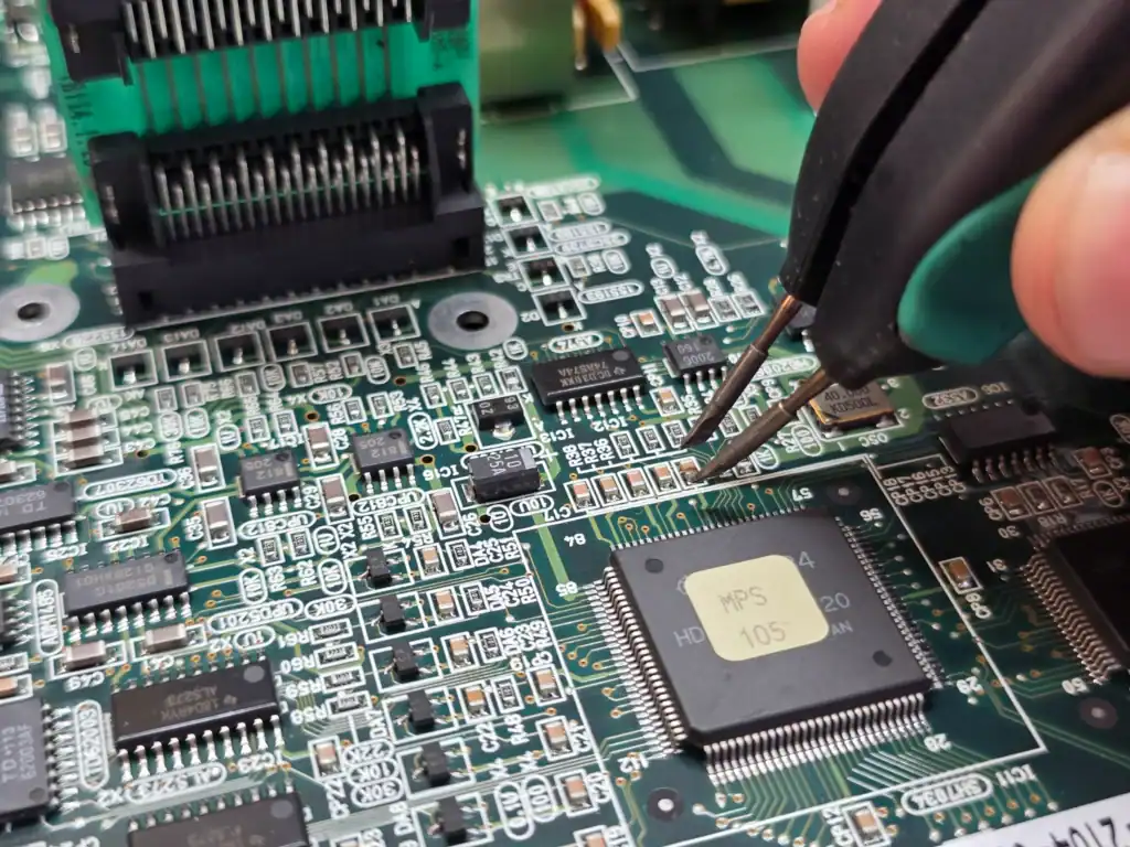 Close-up of Okuma CNC control board during electronic diagnostics and repair