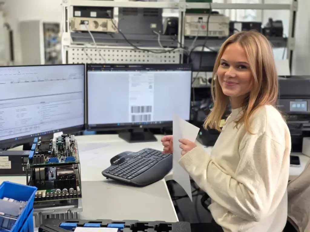Technician processing and testing Okuma CNC electronic components in workshop